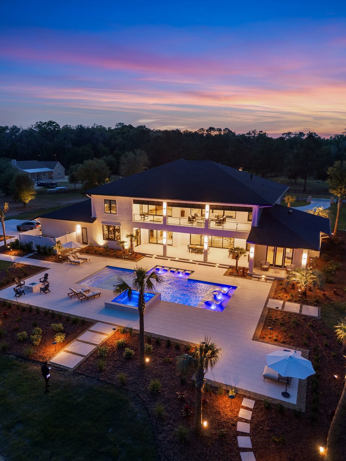 Aerial twilight view of a custom pool, spa, and luxury home built by Old Palm Pool Construction